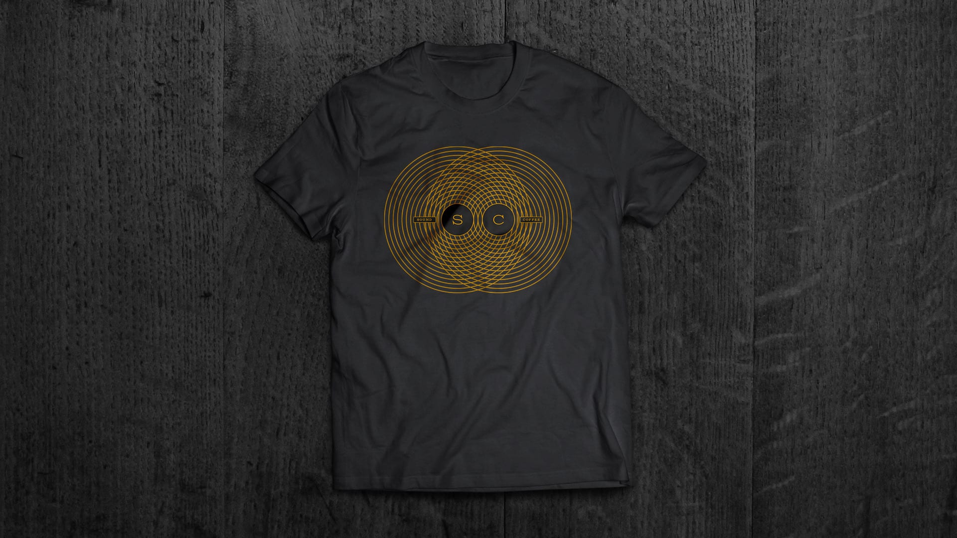 The sound-wave mark in gold on a black T-shirt